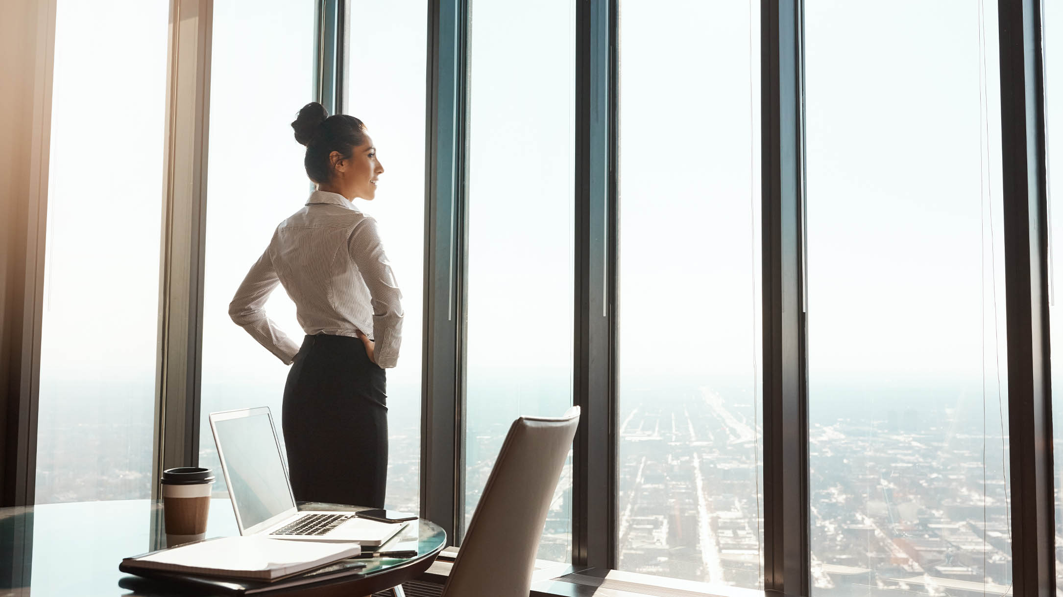 confident woman with her hands on her hips looking out the window