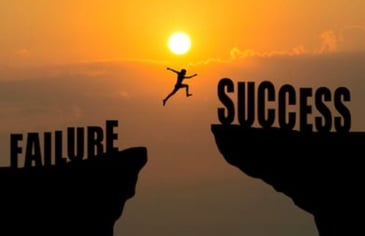 a silhouette of a person jumping from failure to success