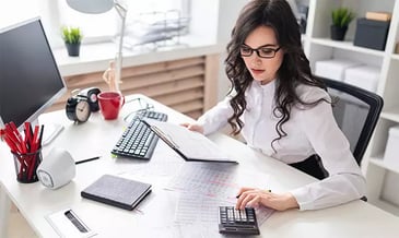woman reading a report and using the calculator