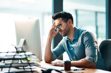 frustrated man looking at his laptop