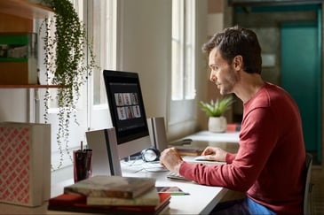 man looking at his monitor in a home office setup