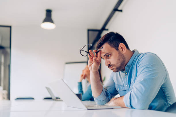 man staring at his laptop looking frustrated
