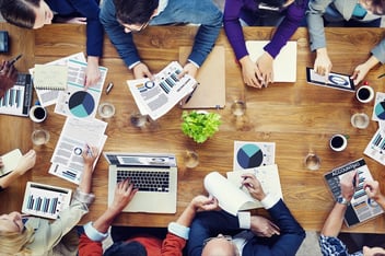 group of people with graphs and reports
