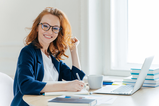 smiling woman holding a pen