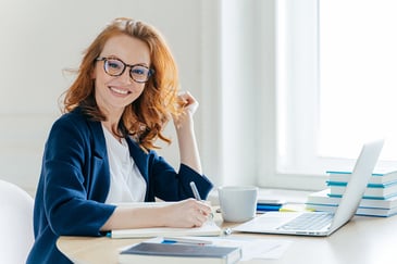 smiling woman holding a pen