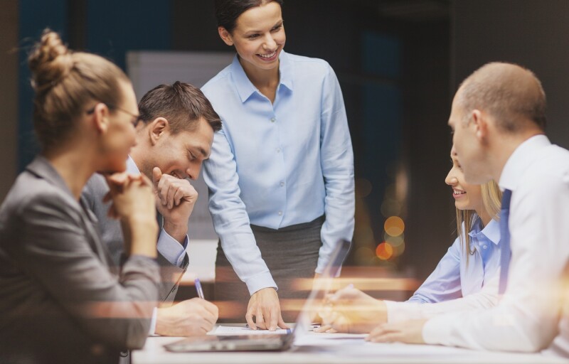 team meeting woman standing up pointing at a report