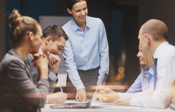 team meeting woman standing up pointing at a report