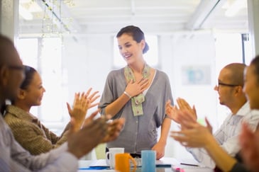 a group of people applauding a woman