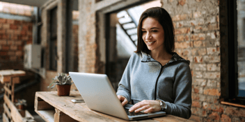 a smiling woman using laptop computer
